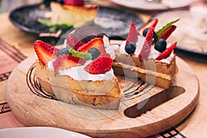 Waffles topping with slices of strawberry and blackberry served with a scoop of ice cream