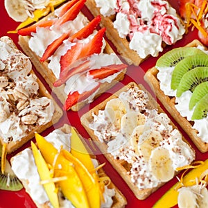 Waffles with whipped cream and fresh fruits on the top