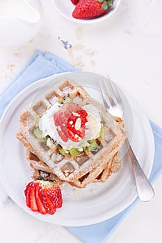 Waffles with wholewheat flour and fruits on a white plate