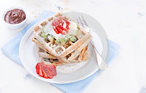 Waffles with wholewheat flour and fruits on a white plate