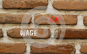 Wage gap symbol. Concept words Wage gap on beautiful brown brick wall on a beautiful brown brick wall background. Business,