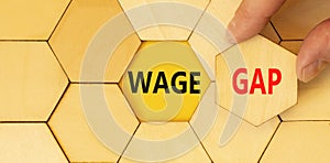 Wage gap symbol. Concept words Wage gap on beautiful wooden puzzles on a beautiful wooden background. Businessman hand. Business,