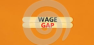 Wage gap symbol. Concept words Wage gap on beautiful wooden stick on a beautiful orange table orange background. Business, support