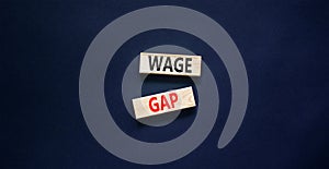 Wage gap symbol. Concept words Wage gap on wooden blocks on a beautiful black table black background. Business, support and wage