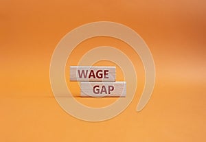 Wage Gap symbol. Concept words Wage Gap on wooden blocks. Beautiful orange background. Business and Wage Gap concept. Copy space