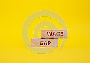 Wage Gap symbol. Concept words Wage Gap on wooden blocks. Beautiful yellow background. Business and Wage Gap concept. Copy space