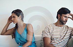 Waging a war of the heart. a young couple having an argument while sitting on their couch at home. photo