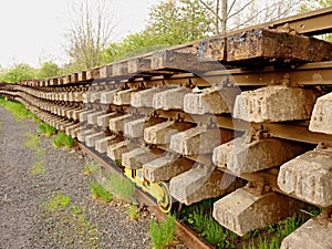 Wagon with extracted old railways. Concrete and wooden sleepers with rail rods