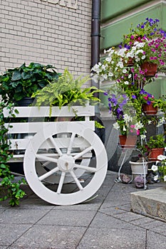 Wagon with flowers near the building wall