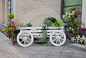 Wagon with flowers near the wall