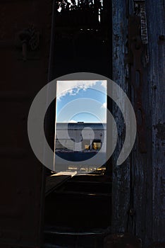 The wagon of an old train through a half-open door of another one
