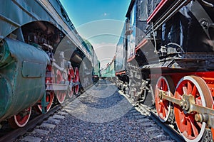 Between wagons of old trains, between two old trains, red metal train wheels