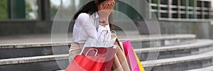 Wailful woman with shop bags near mall