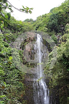 Wailua Falls tumbling over a volcanic rock cliffside in a rainforest in Hana, Maui, Hawaii photo