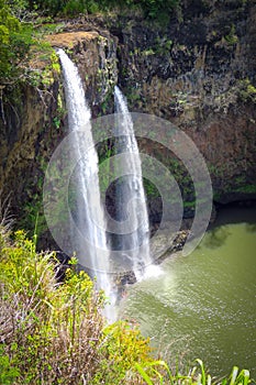 Wailua Falls, twin waterfalls flowing down in a green creek, Kauai, Hawaii, USA