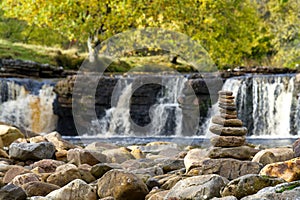 Wain Wath waterfall, with stacked stones in the foreground. Bokeh
