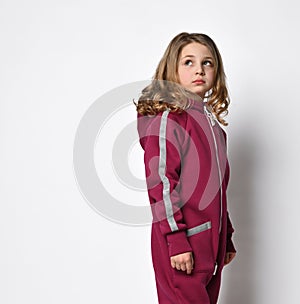 waist-length portrait of a stylish girl in a bordo sports suit with reflective stripes, looks to the side. stylish