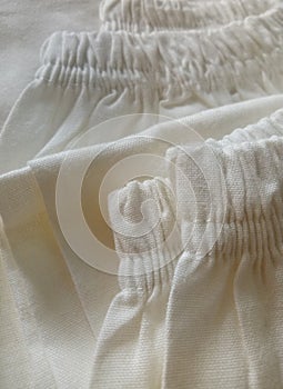 Waist stretchy pants.  Partial top view of white rayon pants photo