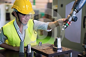 Waist up female inspector check automatic robot arm in factory