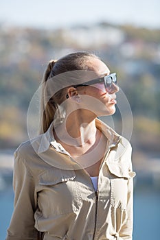 Waist up portrait of blonde person in jumpsuit outdoors