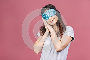 Waist up portrait of cheerful smiling girl in sleeping mask. Attractive funny female in stylish pajama standing and looking away.