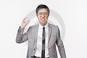 Waist-up portrait of disappointed angry young asian male entrepreneur throwing paper ball at camera with aggressive