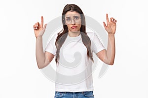 Waist-up portrait of distressed, sad and gloomy indecisive young brunette woman in t-shirt and glasses, shrugging