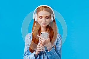 Waist-up portrait good-looking foxy teenage college girl in headphones, listening music, scrolling news feed in morning