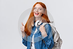 Waist-up portrait joyful cute redhead girl inviting freshmen apply univeristy, got scholarship, smiling showing thumbs