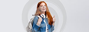 Waist-up portrait joyful cute redhead girl inviting freshmen apply univeristy, got scholarship, smiling showing thumbs