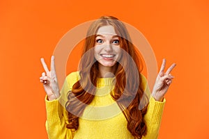 Waist-up portrait lovely and cheerful pretty redhead woman showing peace gestures, smiling camera, travel abroad during