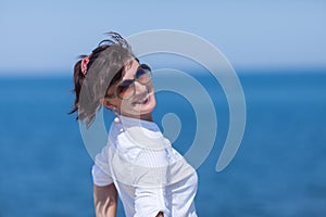 Waist up portrait of middle aged woman against sea