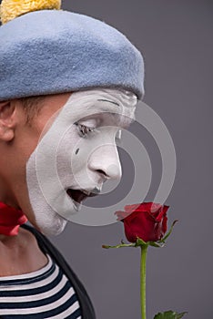 Waist-up portrait of young male mime holding a