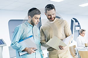 Waist up portrait of young men having conversation about their work plan