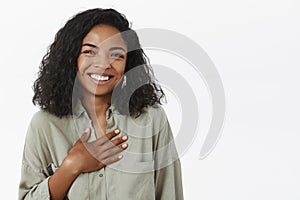 Waist-up shot of amused attractive and stylish young african american female with curly haircut being pleased receiving