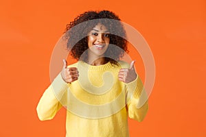 Waist-up shot cute supportive african-american woman feeling happy about great idea, shot thumb-up and smiling, agree