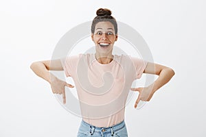 Waist-up shot of excited impressed and happy young woman reacting to impressive unbelievable miracle happened pointing