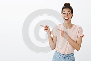 Waist-up shot of happy enthusiastic and excited joyful attractive european female with tan and messy hairbun smiling