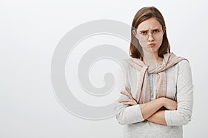 Waist-up shot of sad unhappy and gloomy cute girl with flapped ear frowning and sulking crossing arms over body feeling