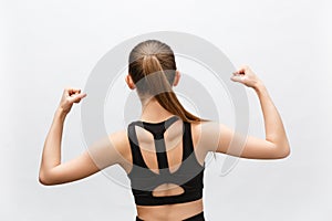 Waist up shot of sporty woman raises hand to show her muscles, feels confident in victory, looks stong and independent