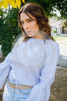 Waist up vertical portrait of young Latina woman posing outside home