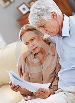 Wait, am I reading this right. Shot of a senior couple looking seriosly at documents.