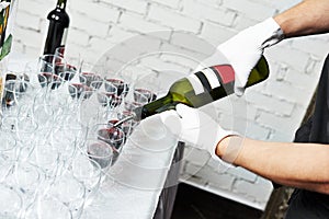 Waiter bartender pouring wine at party