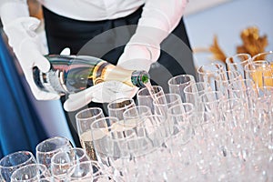 Waiter bartender pouring wine at party