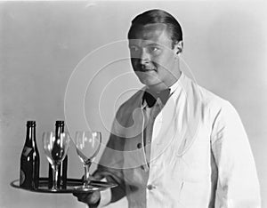 Waiter with beverages on tray photo