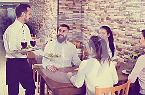 Waiter bringing order to visitors