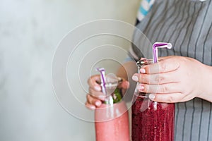 Waiter brings bottles of smoothie in hands photo