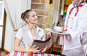 Waiter brings a dish for a nice woman