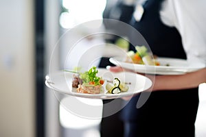 Waiter carrying plates with meat dish