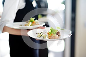 Waiter carrying plates with meat dish